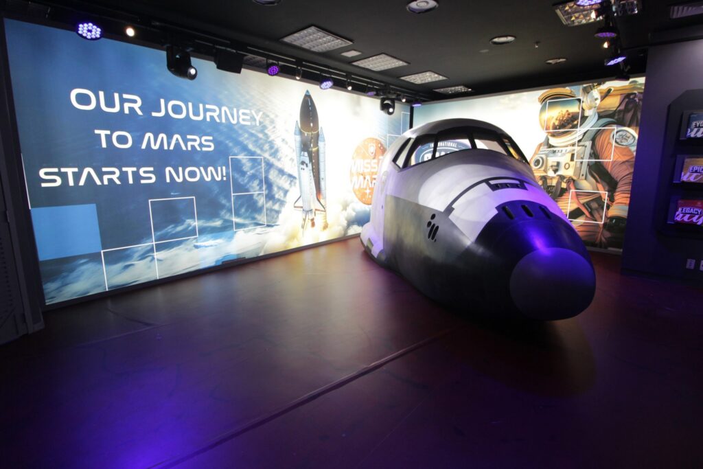 réplica do bico de um foguete espacial com a frase "Our journey to Mars starts now" ao lado