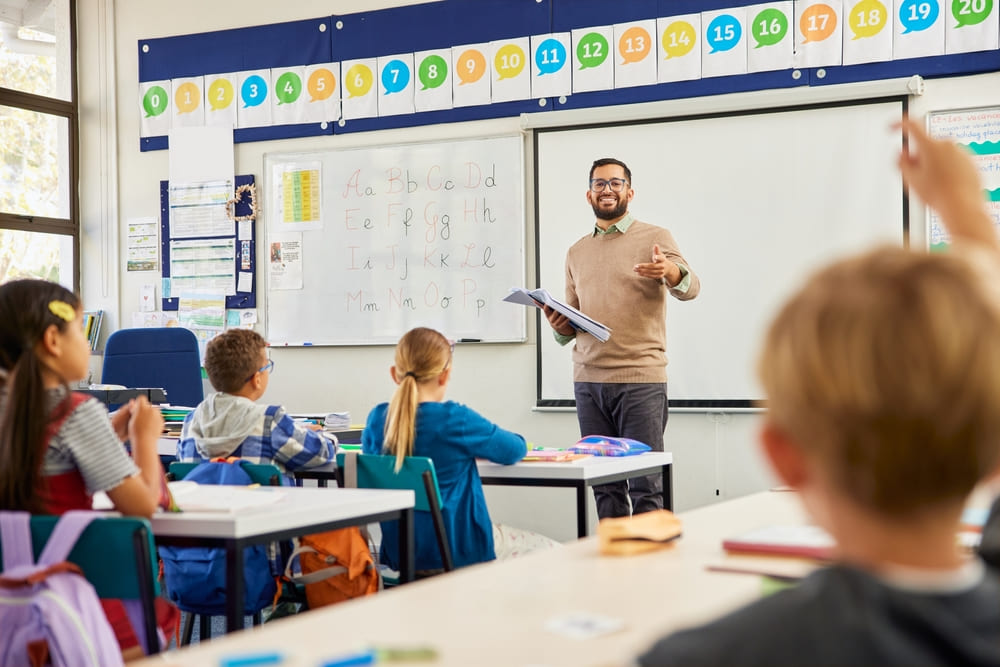 Professor ensina alunos utilizando metodologias ativas, com estudantes participando ativamente da aula.