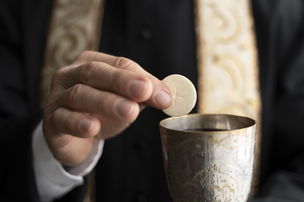 Sacramentais da Igreja Católica em missa, fiéis recebem a Eucaristia na igreja.