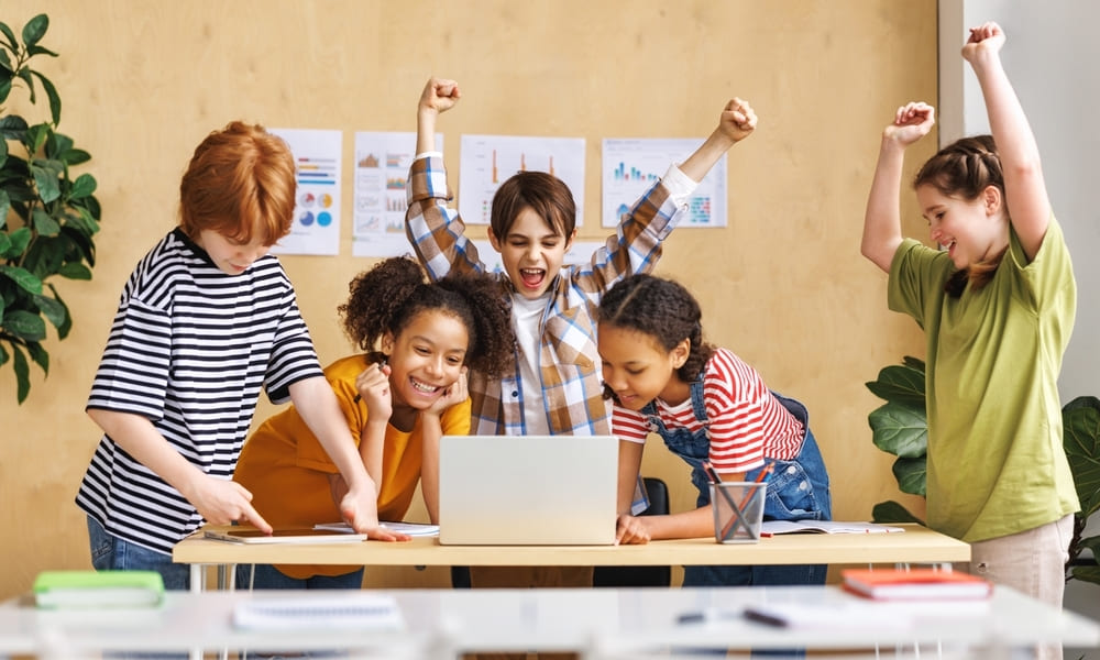 Crianças comemorando o sucesso após resolver um problema, ilustrando os benefícios do método PBL na aprendizagem colaborativa.