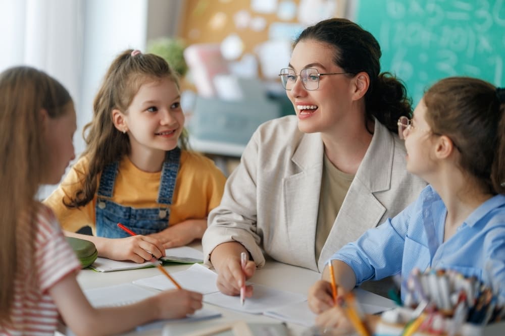 Pedagoga interagindo com crianças em sala de aula, promovendo o aprendizado no Dia da Pedagoga.