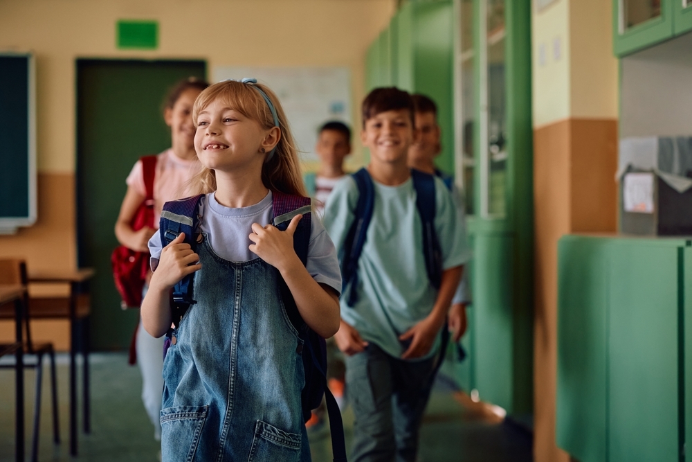 Alunos felizes entrando na sala de aula no Dia da Escola.