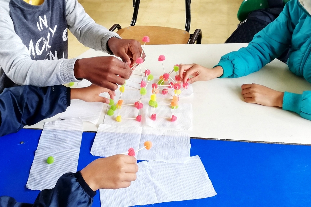 Jovens estudantes utilizando recursos didáticos em sala de aula.