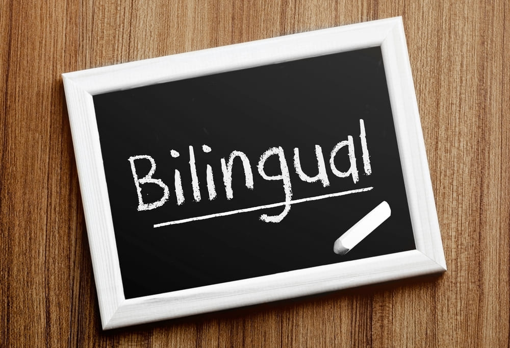 Lousa com a palavra "Bilíngue" escrita em giz, representando o conceito de programa bilíngue.