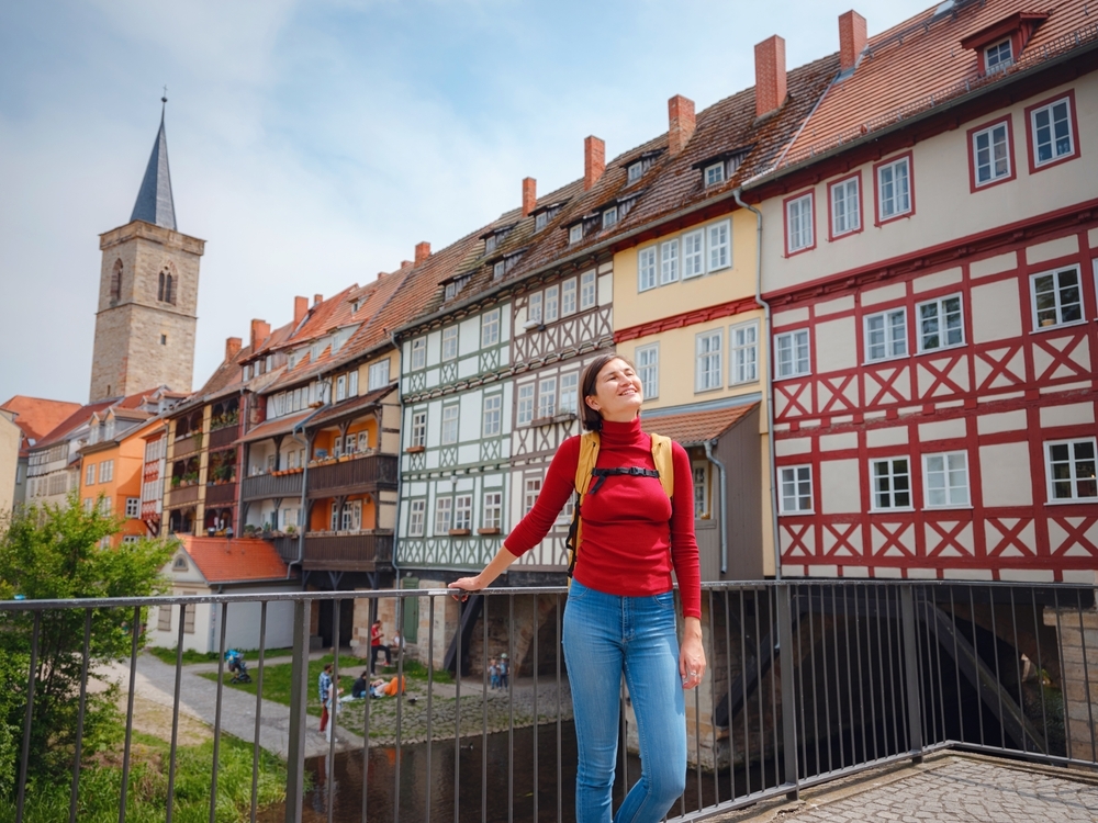 Mulher explorando cidade europeia durante viagem de imersão cultural.
