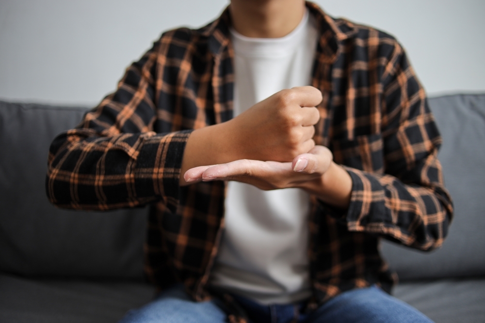 Homem sinalizando o alfabeto em Libras, ilustrando o objetivo principal do ensino bilíngue para surdos.
