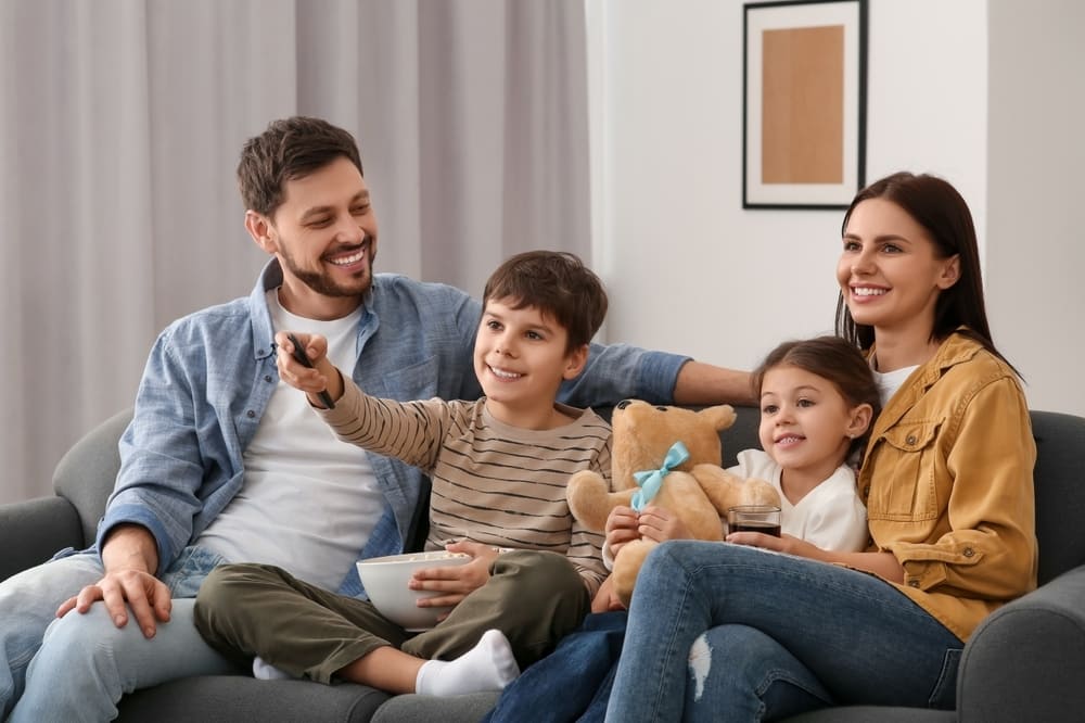 Família assistindo a desenho em inglês em casa mostra que, mesmo dizendo “eu não falo inglês”, é possível apoiar o aprendizado no ensino bilíngue.