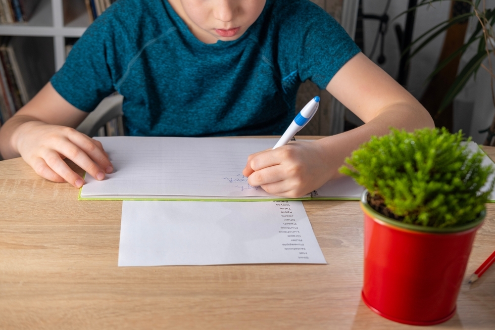 Criança realizando atividade de ensino de inglês em sala de aula.
