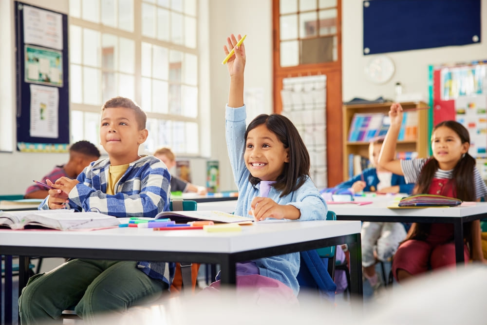 Alunos em sala de aula participando de atividade pedagógica que exemplifica a aplicação do currículo bilíngue na escola.