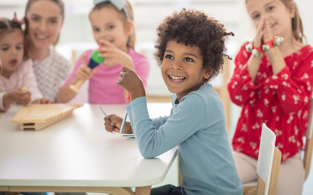 crianças sorriem em sala de aula da Educação Infantil