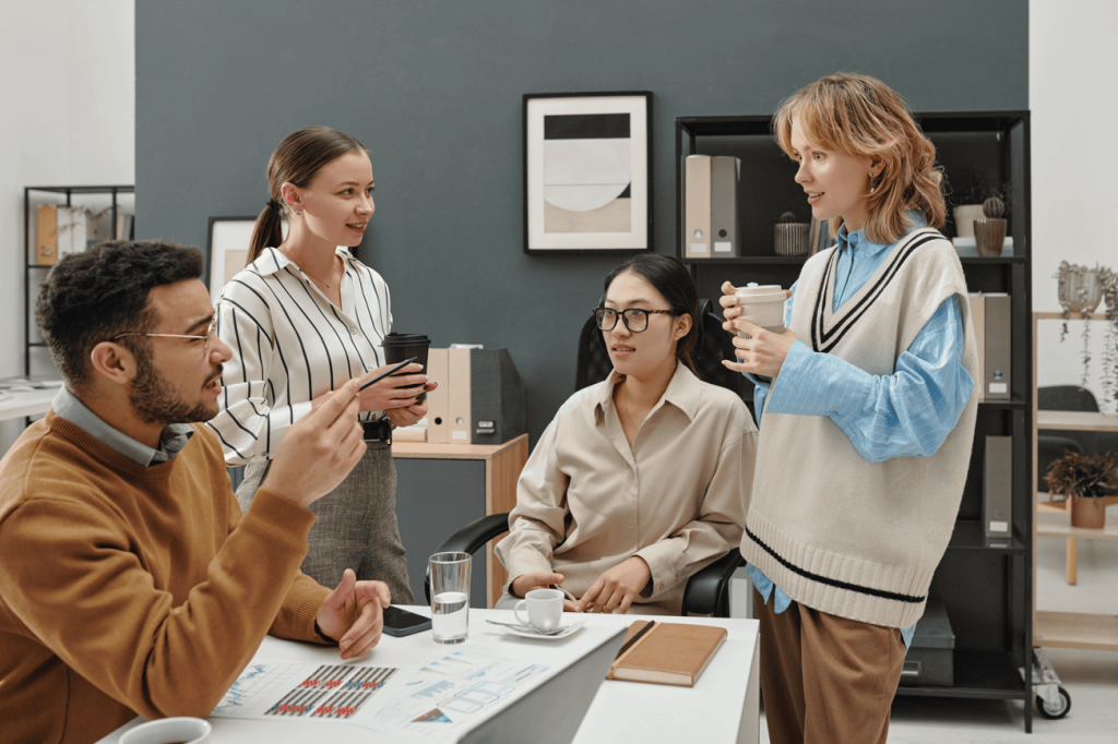 Educadores e gestores em reunião de trabalho discutindo ideias em equipe, simbolizando a gestão democrática da escola.