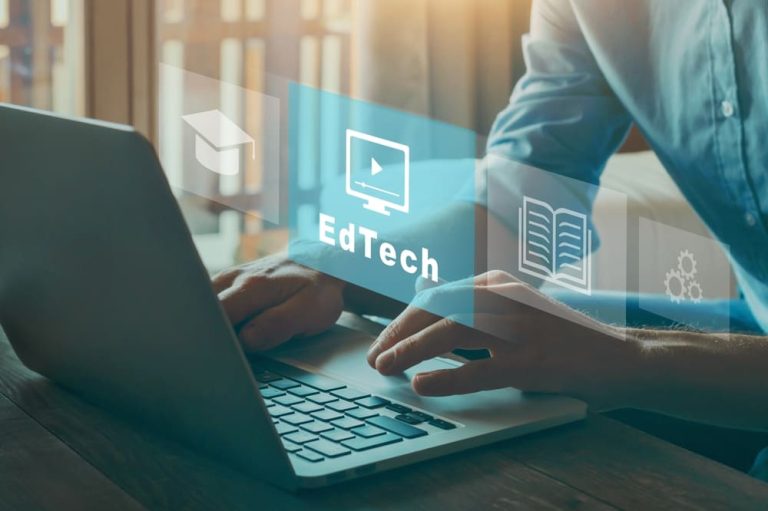 Mãos em laptop com ícones flutuantes representando edtech e ferramentas educacionais digitais.