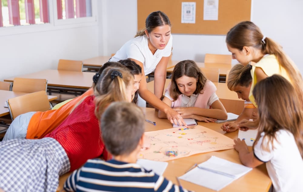 Alunos e professora em sala de aula aplicando o método Freinet em um trabalho colaborativo.