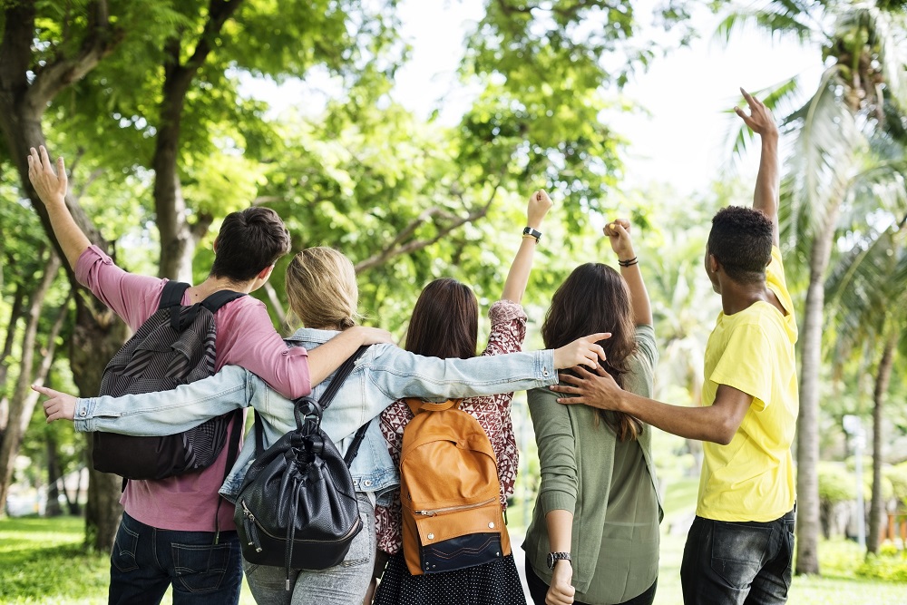 Universitários estudando ao ar livre unidos pelo aprendizado e dia dos estudantes.
