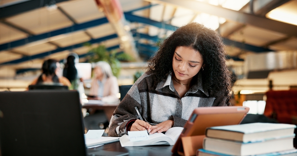 Estudante organizando seu ciclo de estudos com anotações e planilhas.