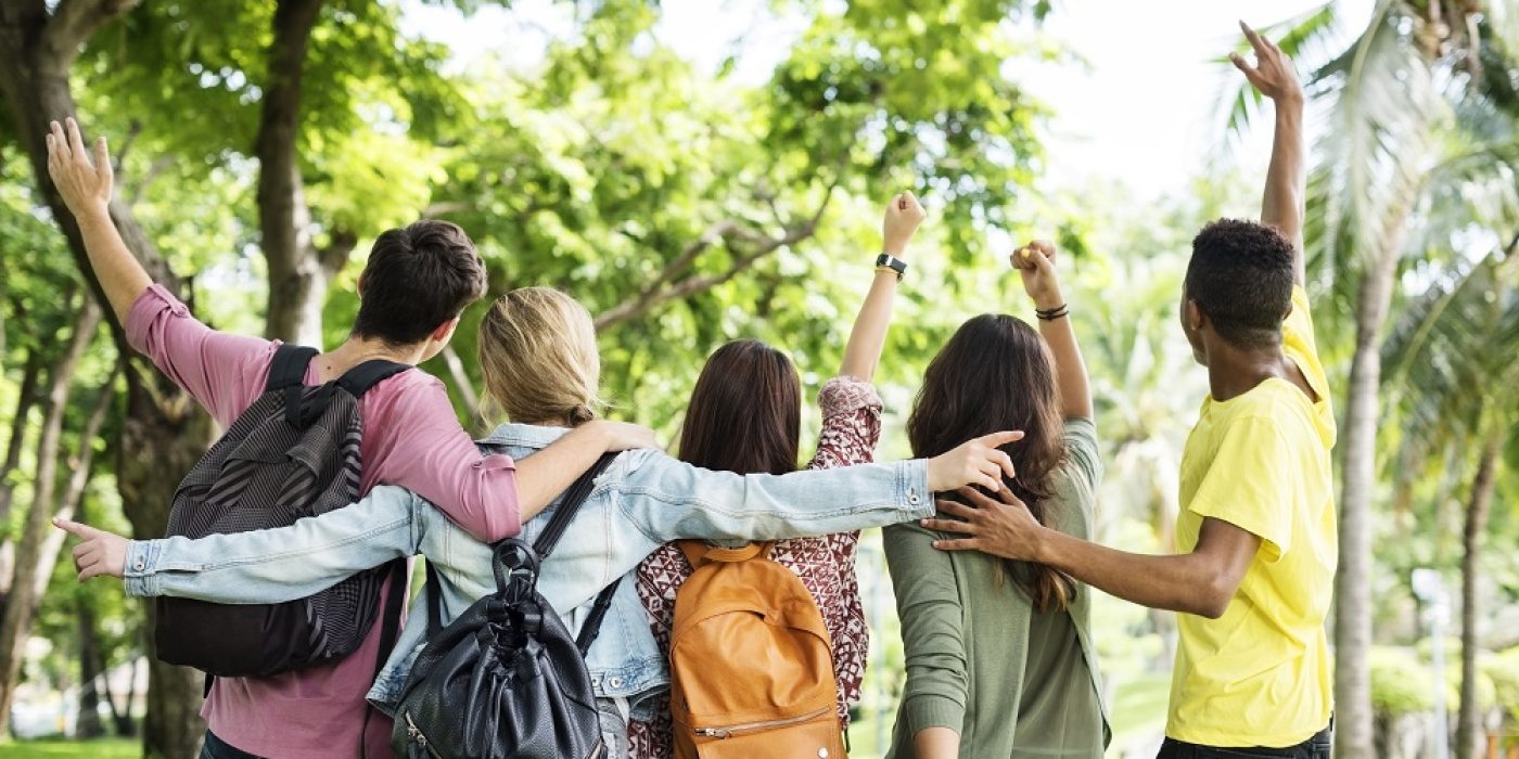 Universitários estudando ao ar livre unidos pelo aprendizado e dia dos estudantes.