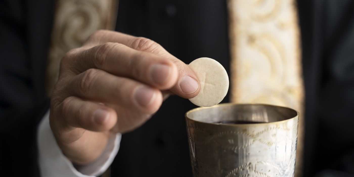 Sacramentais da Igreja Católica em missa, fiéis recebem a Eucaristia na igreja.