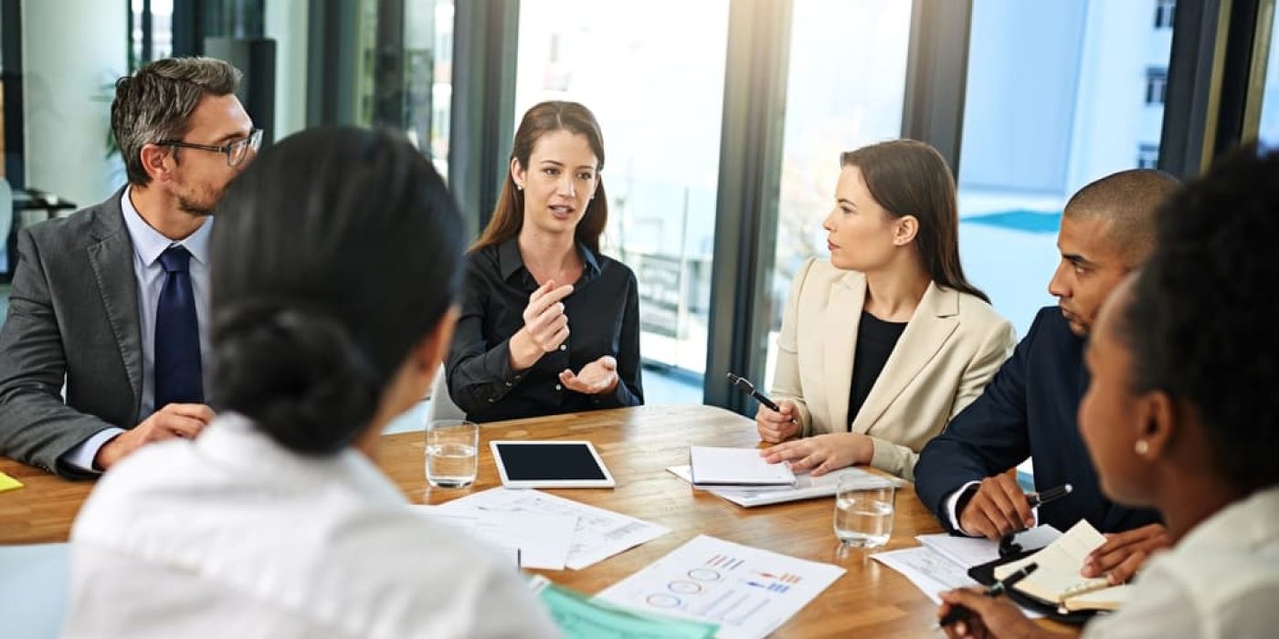 Reunião de negócios utilizando o inglês profissional para discutir estratégias em sala de conferências.