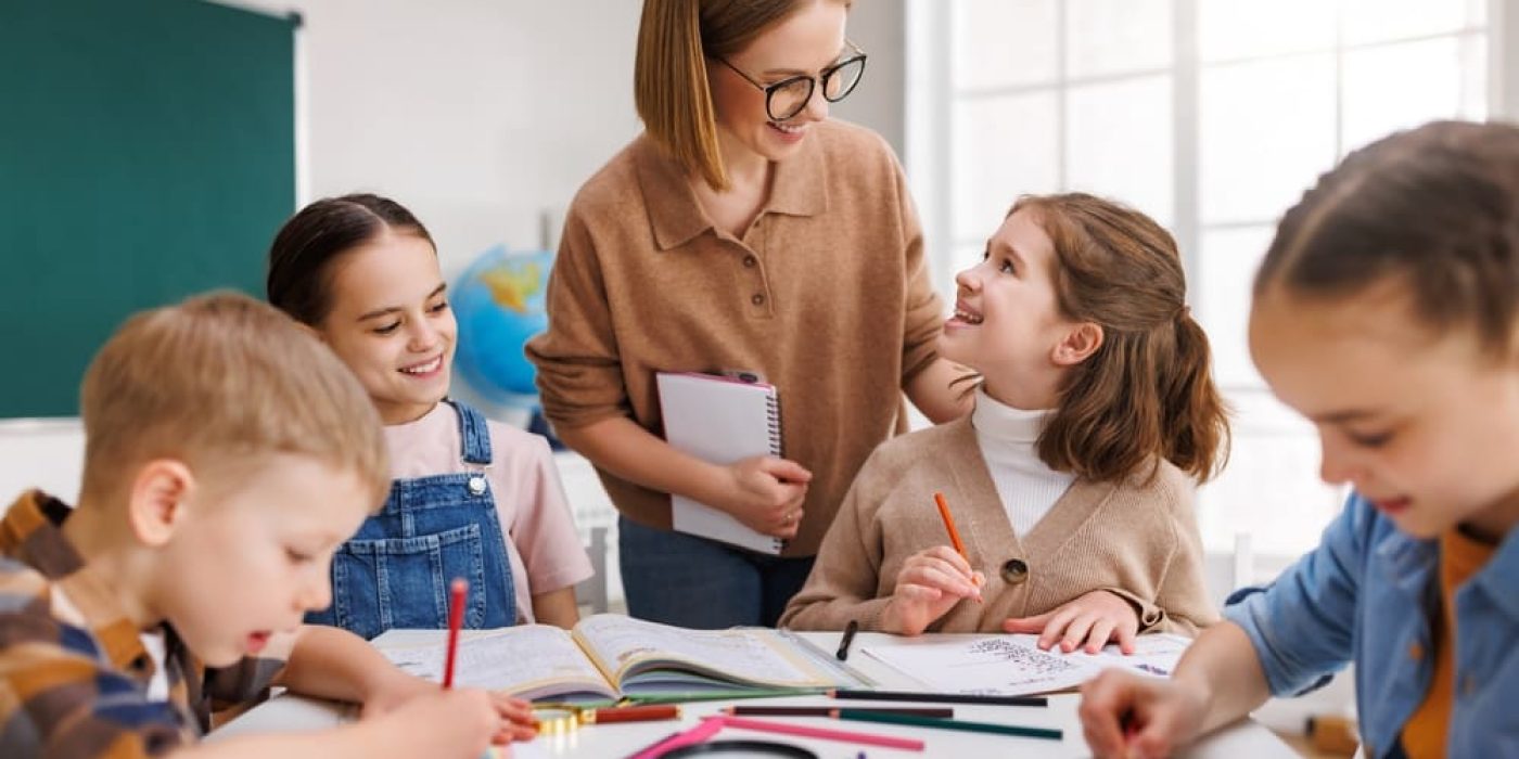 Crianças participando de atividades de ensino religioso em uma sala de aula com a orientação da professora.
