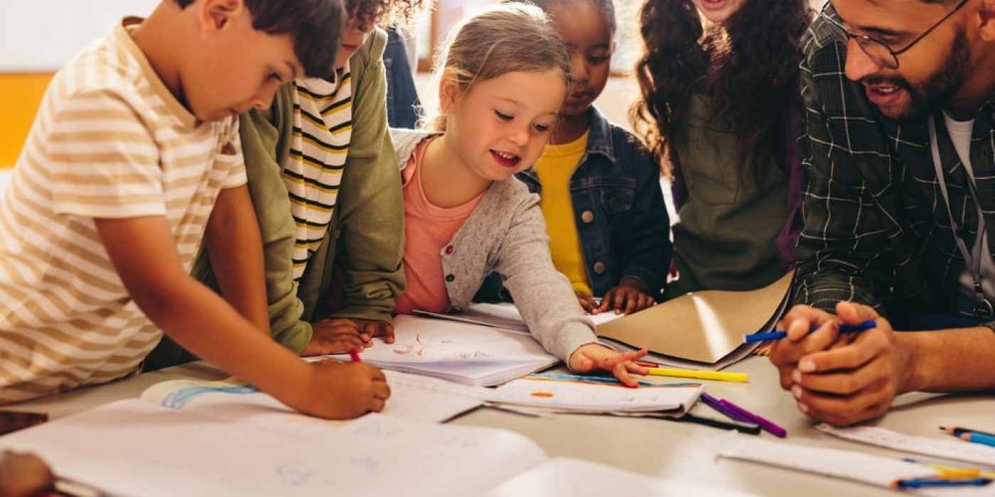 Crianças participando de atividades criativas em grupo durante um plano de aula para Educação Infantil.