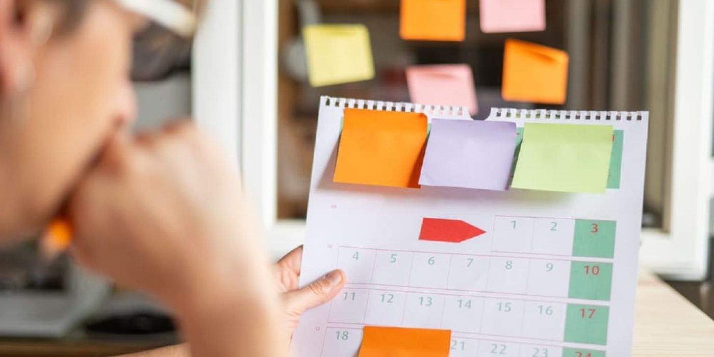 Calendário com post-its usado para planejar a rotina escolar, com prazos, eventos e organização de aulas.
