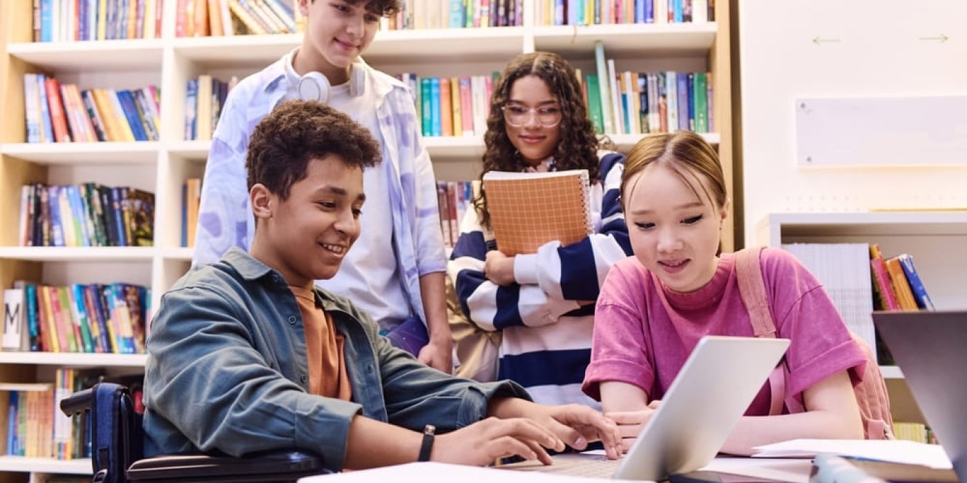 Estudantes participando de atividade em grupo na biblioteca, simbolizando a aprendizagem colaborativa e o trabalho em equipe.