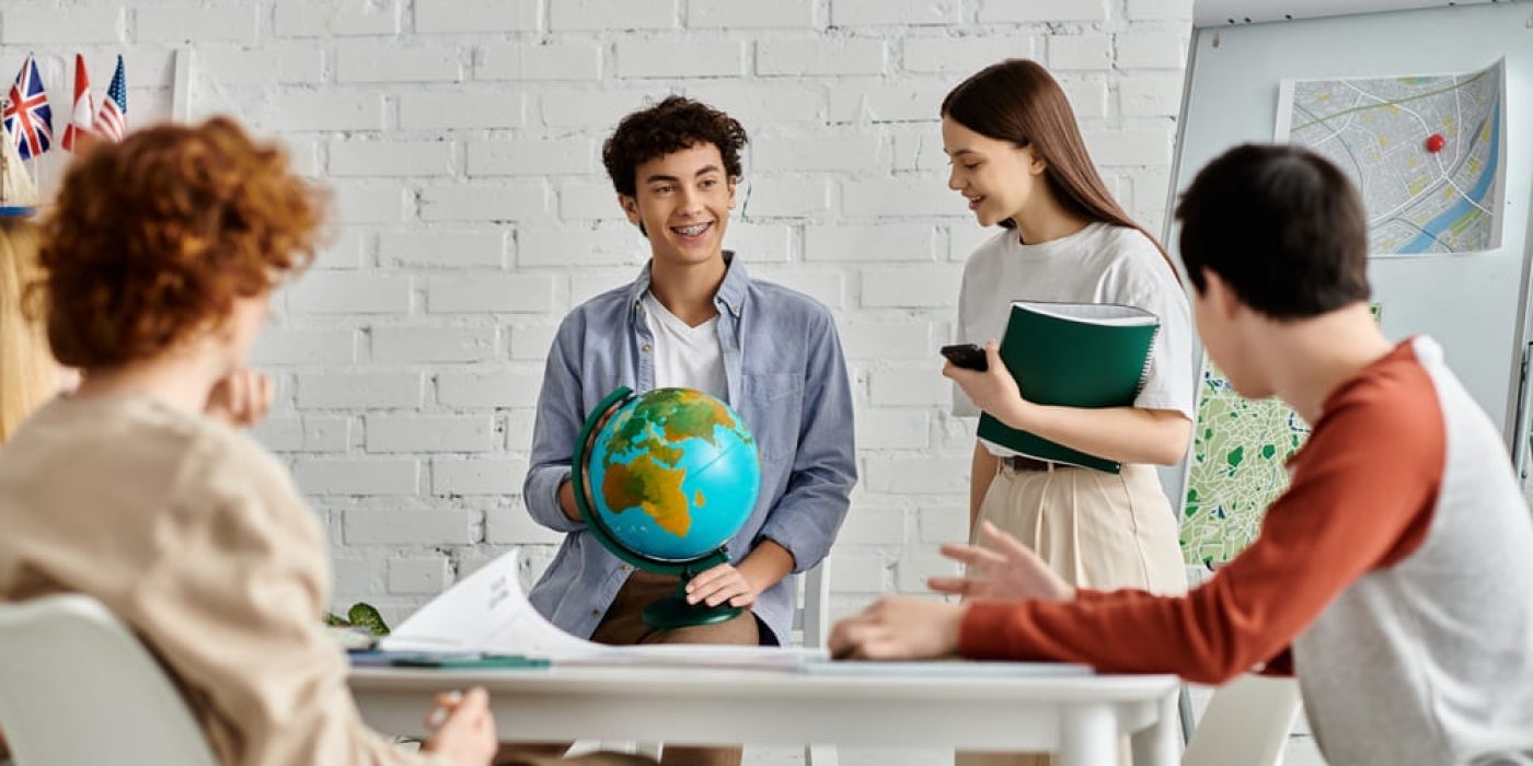 Alunos participando de atividade interativa com globo em sala de aula bilíngue.
