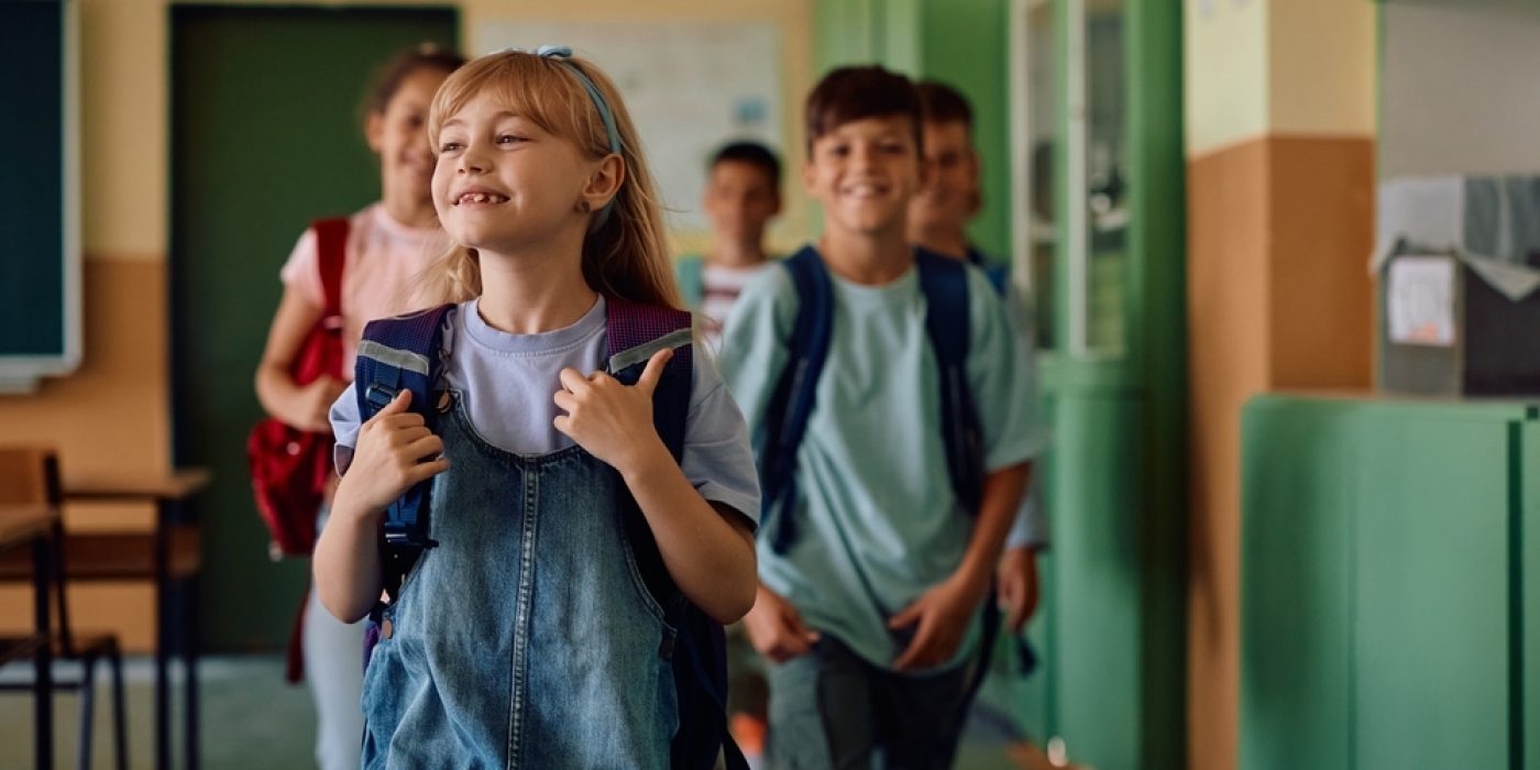 Alunos felizes entrando na sala de aula no Dia da Escola.