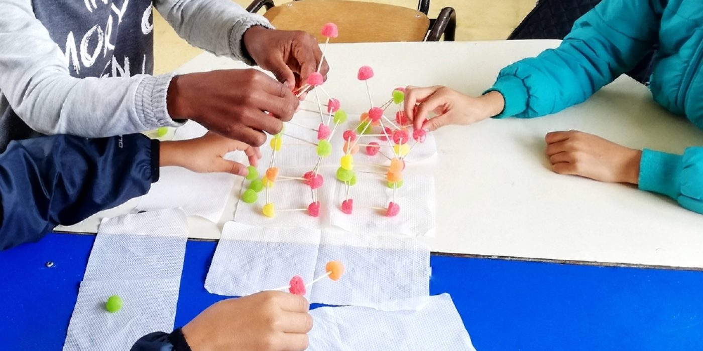 Jovens estudantes utilizando recursos didáticos em sala de aula.